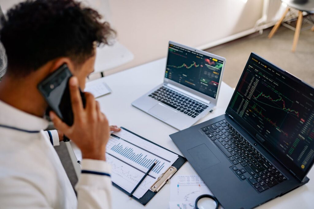 pexels photo 7691740 Man analyzing stock market charts on laptops while talking on a cellphone.